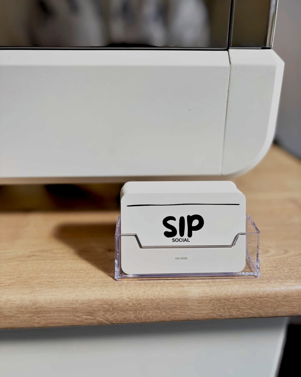 Branded Sip Social cards in a holder on the coffee cart