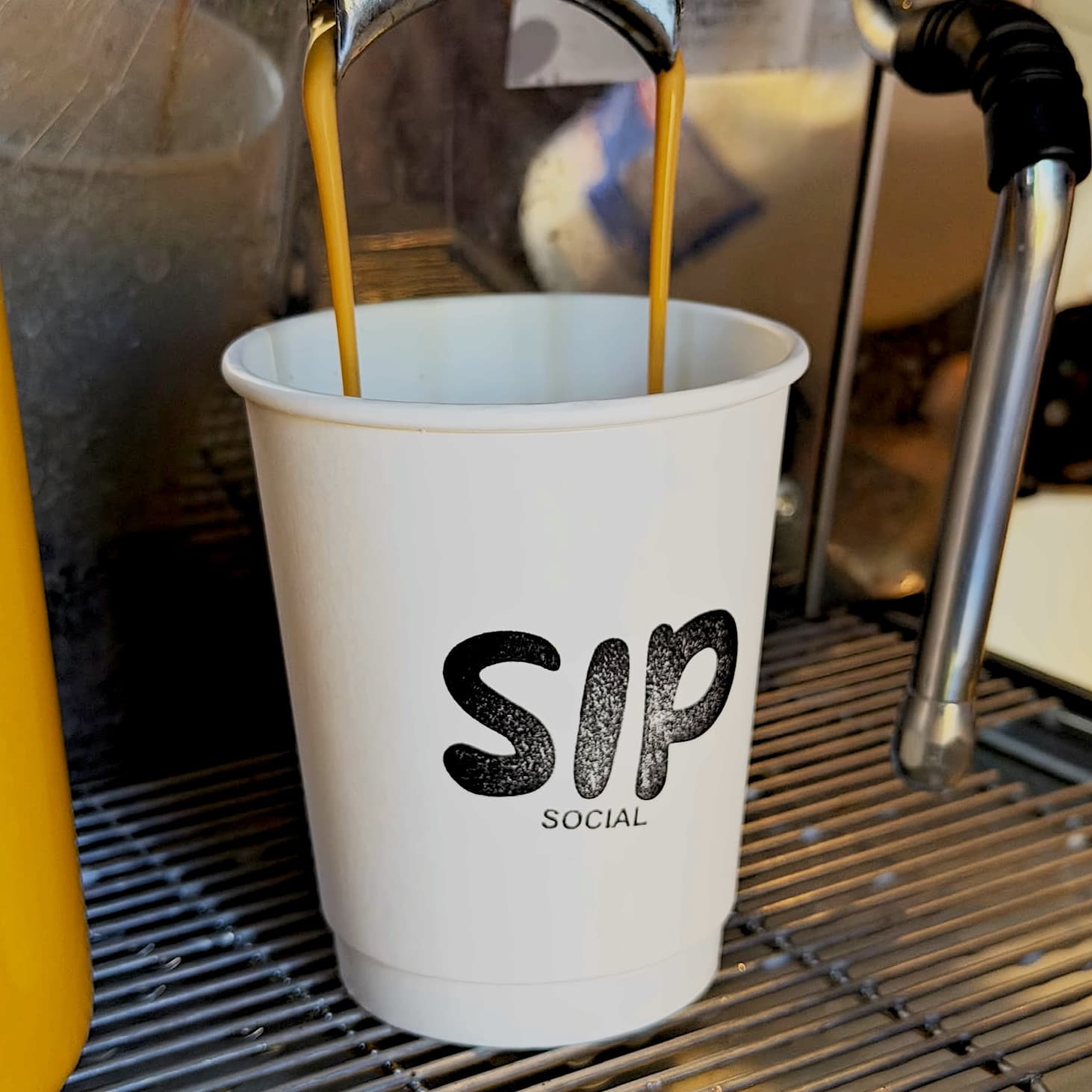 Espresso pouring into a branded Sip Social cup