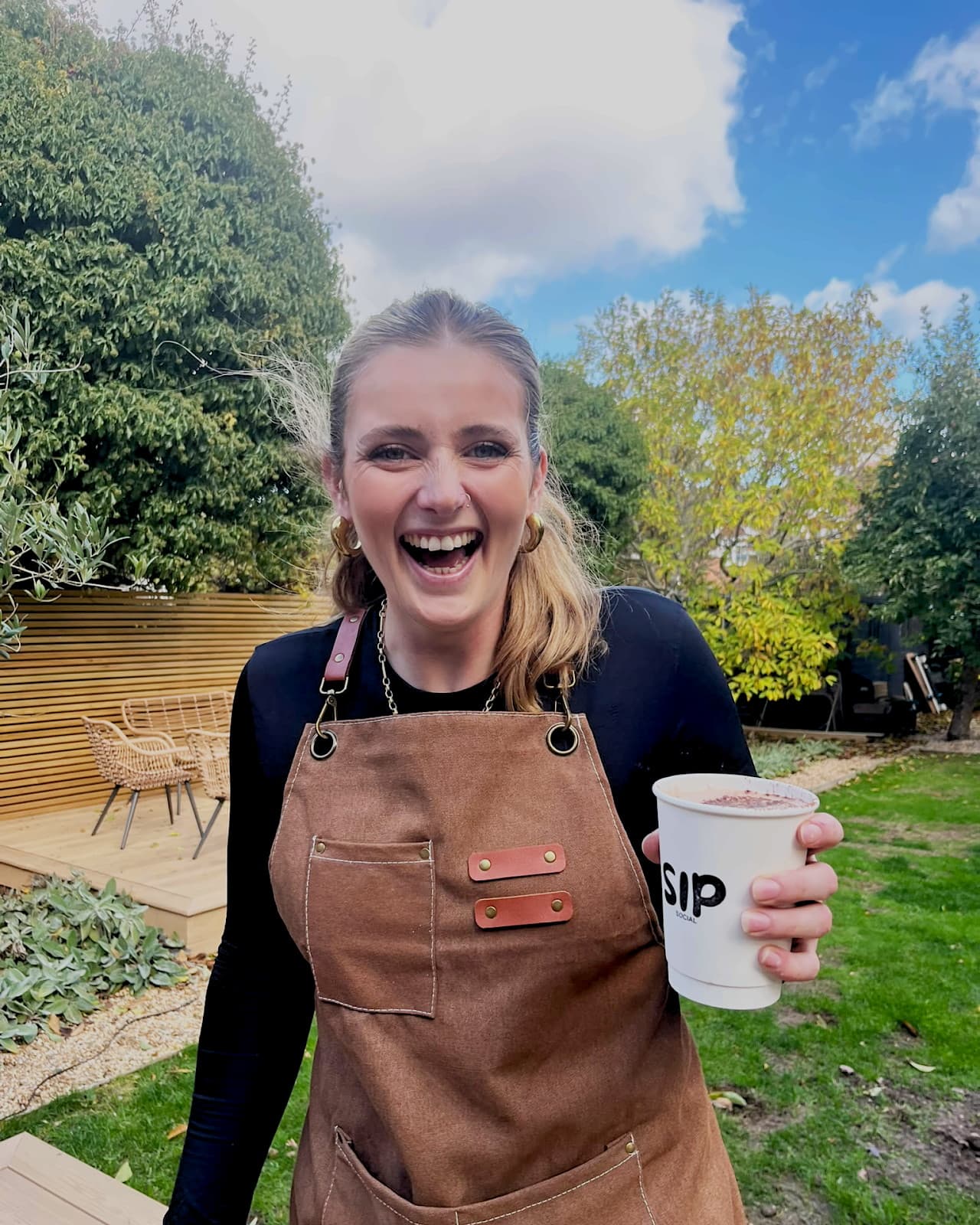 Zoe Stone, founder of Sip Social, holding a freshly made coffee